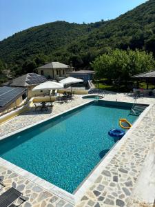 a swimming pool with blue water in front of a mountain at Neromylos in Nikísiani