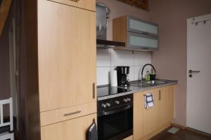 una piccola cucina con armadi in legno e piano cottura di Royal Rose Suite in zentraler Lage a Brema