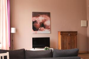 un soggiorno con divano e TV a schermo piatto di Royal Rose Suite in zentraler Lage a Brema