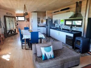 a kitchen and living room with a couch and a table at Casa Del Cipres, Gran vista al mar in Pichilemu