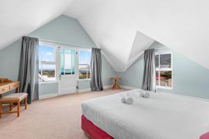 Un dormitorio con una cama, un escritorio y ventanas. en Summerville 20 by Host Agents, en Ciudad del Cabo