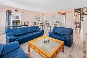 Una sala de estar con sofás azules y una mesa. en Summerville 20 by Host Agents, en Ciudad del Cabo