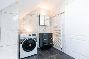 un lavadero con lavadora y secadora en Pitlane-Apartment 2, en Herresbach 2 fotos más