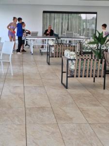 a room with chairs and tables and people in the background at Breakers Resort, Umhlanga, 232 in Durban
