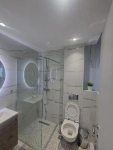 a bathroom with a toilet and a sink and a shower at Cozy Apartment in Asprovalta