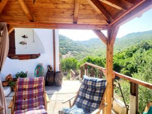 a porch with chairs and a view of the mountains at Casa dell'Artista in S'archittu Cuglieri