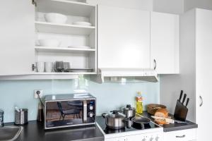 a kitchen with white cabinets and a microwave at Central Big and Bright Resting place in Trondheim +22 photos