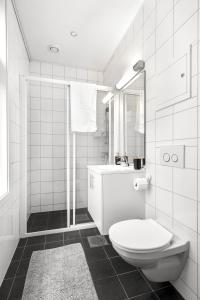a white bathroom with a toilet and a sink at Central Big and Bright Resting place in Trondheim