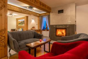 a living room with two couches and a fireplace at Willa Marti GOLD in Zakopane +55 photos