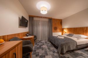 a hotel room with a bed and a living room at Willa Marti GOLD in Zakopane