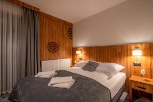 a bedroom with a large bed with wooden walls at Willa Marti GOLD in Zakopane