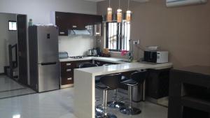 a kitchen with a stainless steel refrigerator and bar stools at Trident Villa in Balaclava
