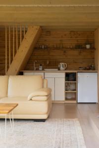 a living room with a couch and a kitchen at Kalna Smīžu pirtiņa in Melturi