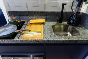 a kitchen counter with a cutting board and a sink at Vista Alta/Academia/Insper e Hosp.São Luiz 650mts in Sao Paulo