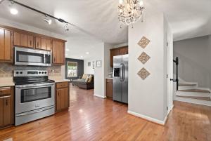 a kitchen with stainless steel appliances and wooden cabinets at 5 Minutes from Hospitals and UK! in Lexington