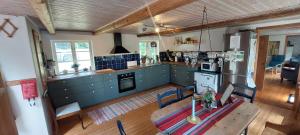 a kitchen with a wooden table and blue cabinets at Fridfullt sommarhus mitt på Österlen nära Simrishamn, Tomelilla och Ystad in Gärsnäs