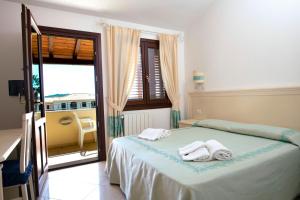 a bedroom with a bed with towels on it at Guesthouse La Locanda - Comfy Rooms & Local Food in Porto San Paolo