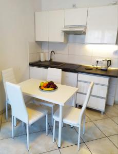 a kitchen with a table with a bowl of fruit on it at Apartamenty Plac Neptuna in Międzyzdroje