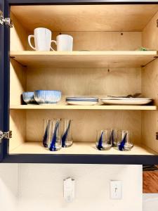 un estante con platos y tazas y platos. en Dallas Modern Apt, en Dallas 2 fotos más