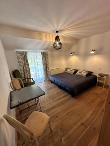 Un dormitorio con una cama, una mesa y una silla. en La Maison Colette, en Les Eyzies-de-Tayac