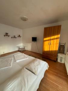 Un dormitorio con una cama blanca y un armario de madera. en KID Apartments, en Cluj-Napoca