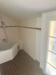 a white bathroom with a tub and a window at La Maison Colette in Les Eyzies-de-Tayac +11 photos