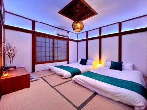 a bedroom with two beds in a room with windows at guesthouse大阪城 in Osaka