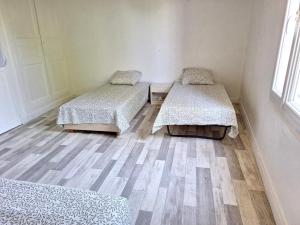 een kamer met twee bedden en een houten vloer bij La Maison Douessine - Hyper Centre Doué La Fontaine - WIFI gratuit -Proche Bioparc Zoo in Doué-la-Fontaine +8 foto's