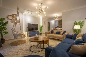 a living room with blue couches and a tv at Skyline Premium Properties in Alexandria