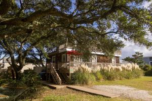 a house on a hill with a tree at Vintage OBX in Sanderling