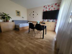 a living room with a table and chairs and a bed at József Attila Apartman Hajdúszoboszló in Hajdúszoboszló