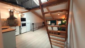a kitchen with a spiral staircase leading to a loft at Au mignon filet de St Nazaire in Saint-Nazaire-en-Royans +10 photos