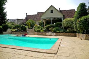 a house with a swimming pool in front of a house at Le domaine du chêne vert in Monthou-sur-Bièvre