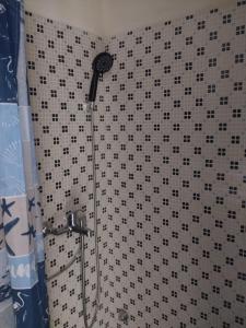 a shower with a black and white tiled wall at dimora del pescatore in Savelletri di Fasano +15 photos