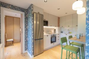 a kitchen with a stainless steel refrigerator and a table at Zubimusu - baskeyrentals in Zestoa
