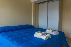 a blue bed with towels on top of it at Gente del Sur - Odino in Ushuaia +82 photos