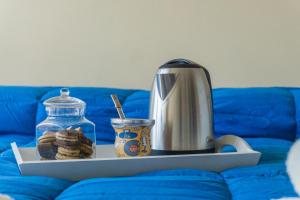 a tea kettle and cookies on a tray on a couch at Gente del Sur - Odino in Ushuaia