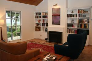 a living room with a couch and chairs and bookshelves at Kia Ora Lookout Retreat in Gloucester