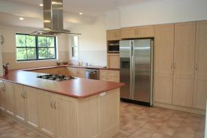 a kitchen with wooden cabinets and a stainless steel refrigerator at Kia Ora Lookout Retreat in Gloucester