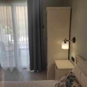 a bedroom with a bed and a door with a window at Pansion Nikos in Patitiri