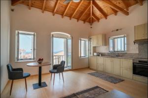 a kitchen with a table and chairs and windows at Neapolis Oasis -- Upper House in Neapoli Voion