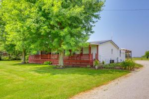 a white house with a red fence and trees at North Fairfield Family Home with Hot Tub and Porch! in Willard