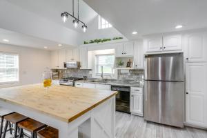 Una cocina con gabinetes blancos y un refrigerador de acero inoxidable. en Ohio Farmhouse Retreat with Fire Pit and Patio, en Monroeville