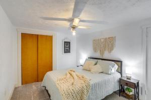 Un dormitorio con una cama y un ventilador de techo. en Ohio Farmhouse Retreat with Fire Pit and Patio, en Monroeville