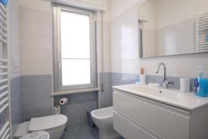 a white bathroom with a toilet and a sink at Lago Blu in Stresa +14 photos