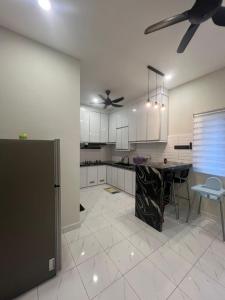 a kitchen with a table and a ceiling fan at Homestay Langkawi Guesthouse 5 bedrooms in Kuah