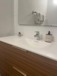 ein weißes Badezimmer mit Waschbecken und Spiegel in der Unterkunft Motel Rovli in Skærbæk