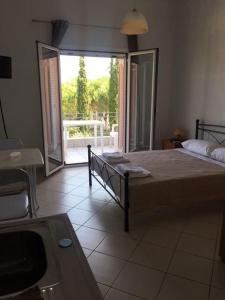 a bedroom with a bed and a view of a balcony at Pefki Apartment 6 in Artemísion