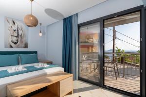 a bedroom with a bed and a balcony at Elena's Luxury Sea View House 2 in Neos Marmaras