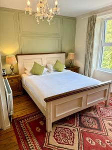 a bedroom with a large bed with a chandelier at Fairhaven in Betws-y-coed
